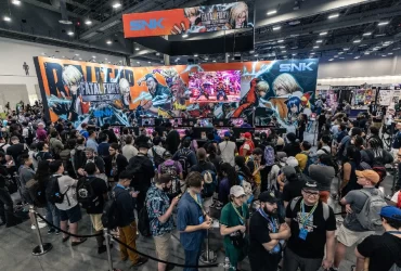 Público reunido em frente ao estande da SNK na Evo, com destaque para o banner de Fatal Fury: City of the Wolves e uma tela exibindo gameplay ao vivo.