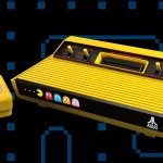 Edição especial do Atari 2600+ Pac-Man com console amarelo, joystick sem fio e LED decorativo dos fantasmas.