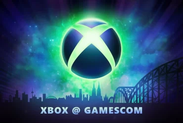ogotipo iluminado do Xbox flutua sobre uma paisagem urbana estilizada de Colônia, Alemanha, com destaque para a catedral e ponte Hohenzollern, ao fundo de um céu nebuloso em tons de verde, azul e roxo. Texto abaixo diz "Xbox @ Gamescom".