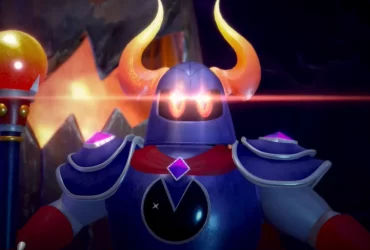 Personagem em armadura com chifres laranja e capa vermelha, segurando um cajado, com um brilho vermelho vindo de seus olhos.