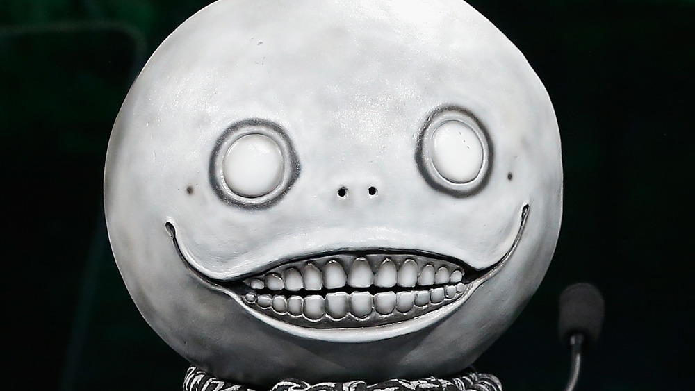 Yoko Taro usando sua icônica máscara de lua durante um evento da indústria de games.