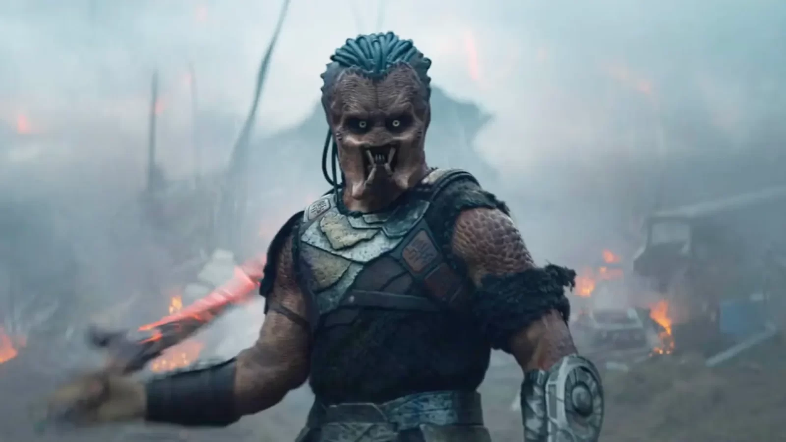 Predador segurando duas armas em posição de ataque no filme Predator: Badlands