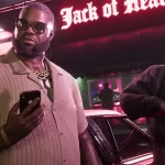 Cena de GTA VI com dois personagens masculinos usando correntes de ouro e óculos escuros, em frente a um clube chamado "Jack of Hearts", com iluminação noturna em tons de rosa neon.