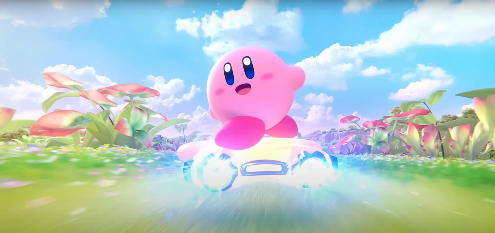 Kirby sorridente pilota uma estrela brilhante em alta velocidade por um campo florido, com céu azul e nuvens ao fundo.