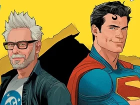 Ilustração em estilo de quadrinhos mostrando James Gunn ao lado do Superman. Gunn aparece com cabelos brancos, barba e óculos, vestindo camiseta da DC e jaqueta aberta. Superman está sorridente, de braços cruzados, usando seu traje clássico azul e capa vermelha, com o icônico “S” no peito. O fundo é amarelo vibrante com detalhes gráficos em preto.