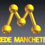 Logo clássico da Rede Manchete em dourado, exibido em fundo cinza, com a letra “M” formada por esferas conectadas.