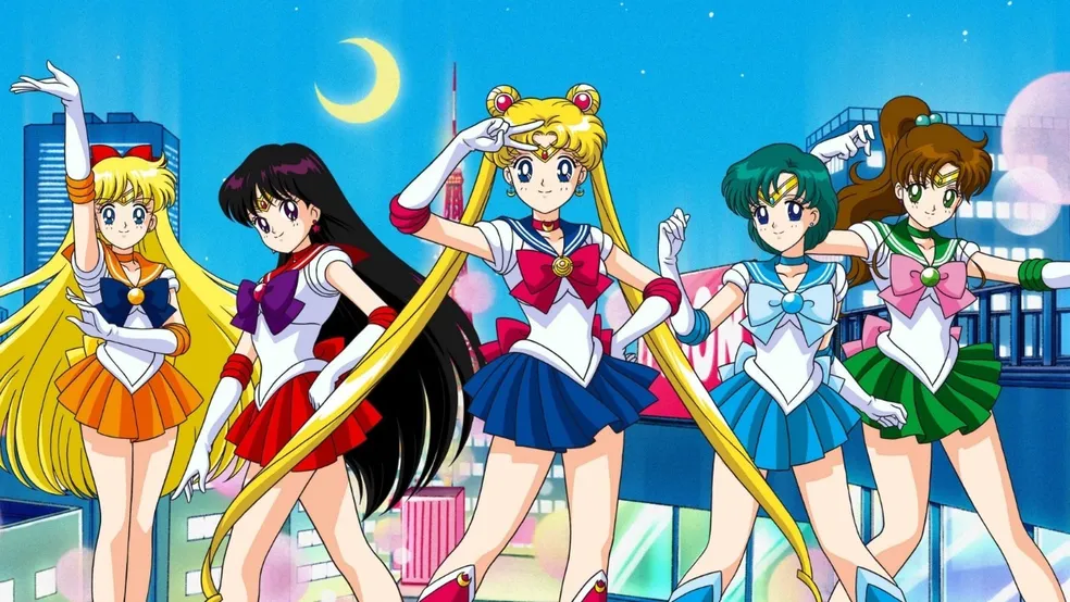 As guerreiras Sailor Moon em frente à cidade iluminada, representando os animes que marcaram a infância no Brasil.
