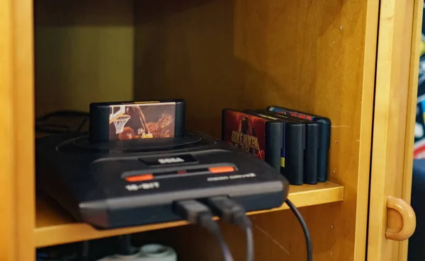 Console de videogame retrô com cartuchos físicos sobre a mesa, representando a era dos jogos em mídia física.