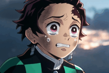 Close-up de Tanjiro Kamado, personagem de anime com cabelo preto avermelhado e brincos de hanafuda, chorando com lágrimas escorrendo pelo rosto e expressão de profunda tristeza, em cena do anime Demon Slayer