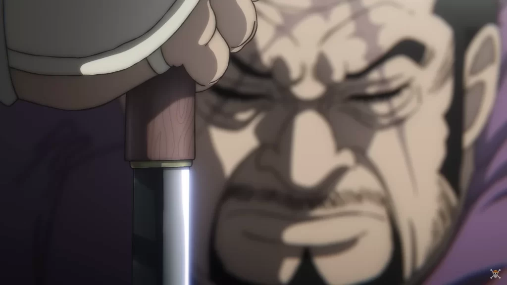 O Almirante Fujitora, de One Piece Film: Red, segura sua espada com expressão séria e olhos fechados, representando seu senso de justiça e reflexão interior.