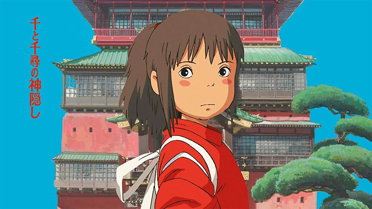 Chihiro vestindo quimono vermelho em frente à casa de banhos tradicional japonesa em cena de A Viagem de Chihiro, filme do Studio Ghibli dirigido por Hayao Miyazaki