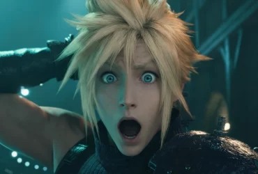 Cloud Strife, de Final Fantasy VII Remake, com expressão de surpresa, cabelo loiro espetado e armadura no ombro em ambiente futurista