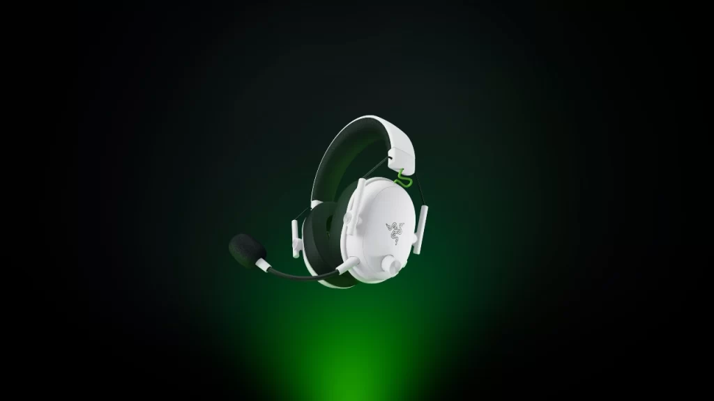 Headset gamer Razer BlackShark V3 White Edition para Xbox na cor branca, com microfone destacável, sobre fundo escuro com iluminação verde.