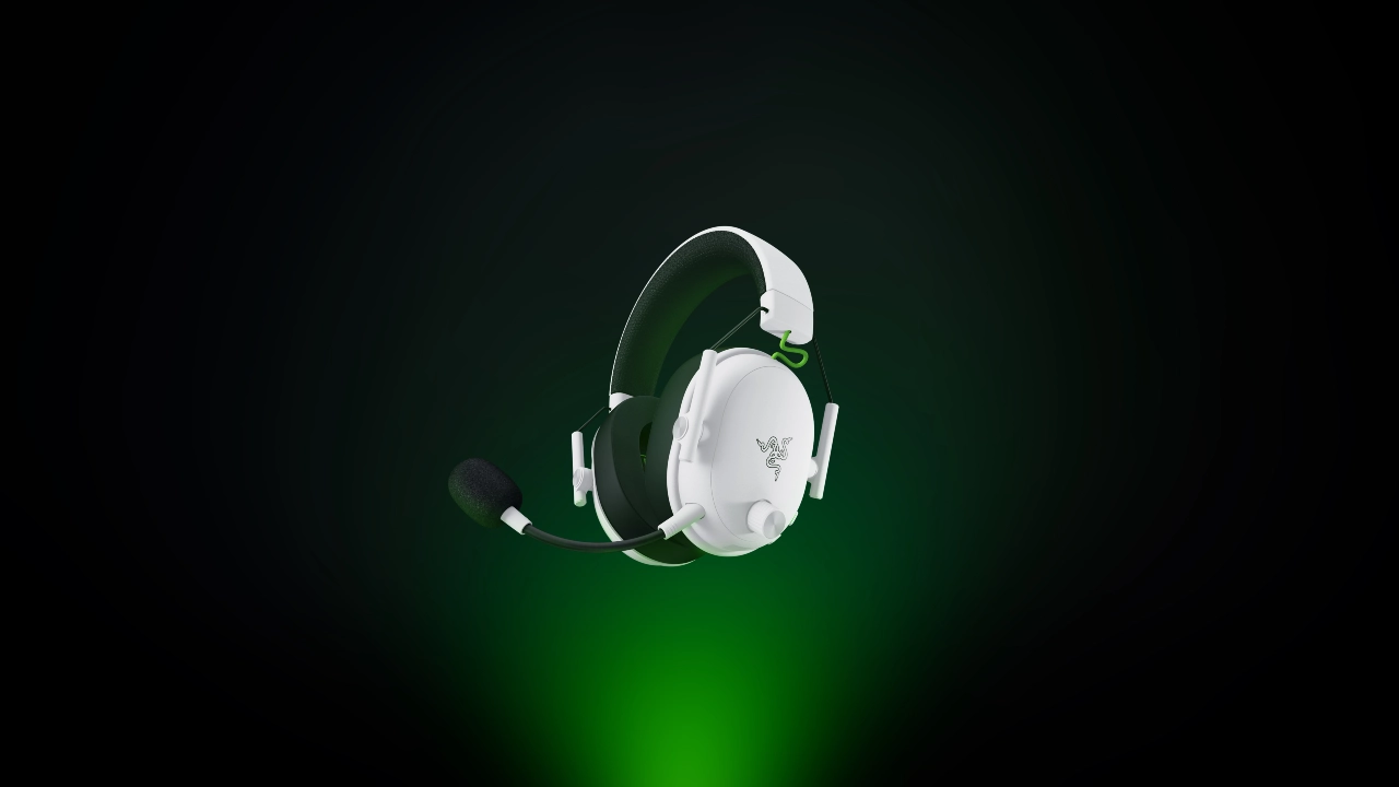 Headset gamer Razer BlackShark V3 White Edition para Xbox na cor branca, com microfone destacável, sobre fundo escuro com iluminação verde.