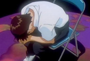 Shinji Ikari encolhido e chorando, abraçado às próprias pernas, sentado em uma cadeira metálica sobre um chão roxo, em cena de Neon Genesis Evangelion.