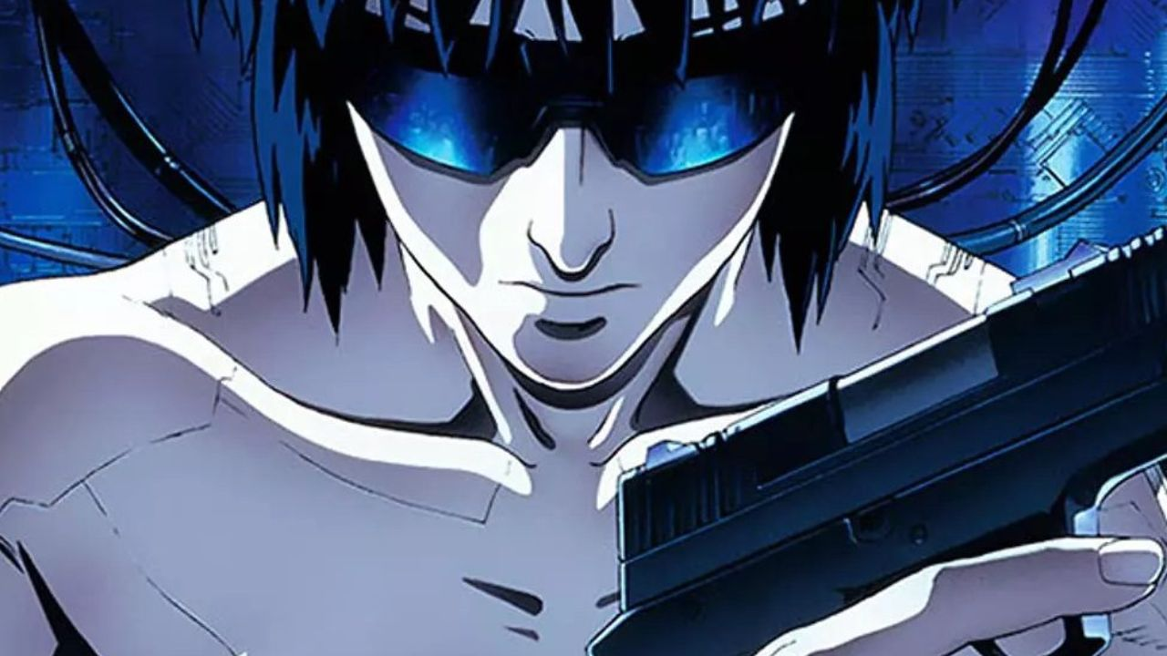 Personagem de Ghost in the Shell em close, com cabelo escuro e viseira azul brilhante, segurando uma arma em um cenário tecnológico de tons azuis, sugerindo introspecção e tensão.