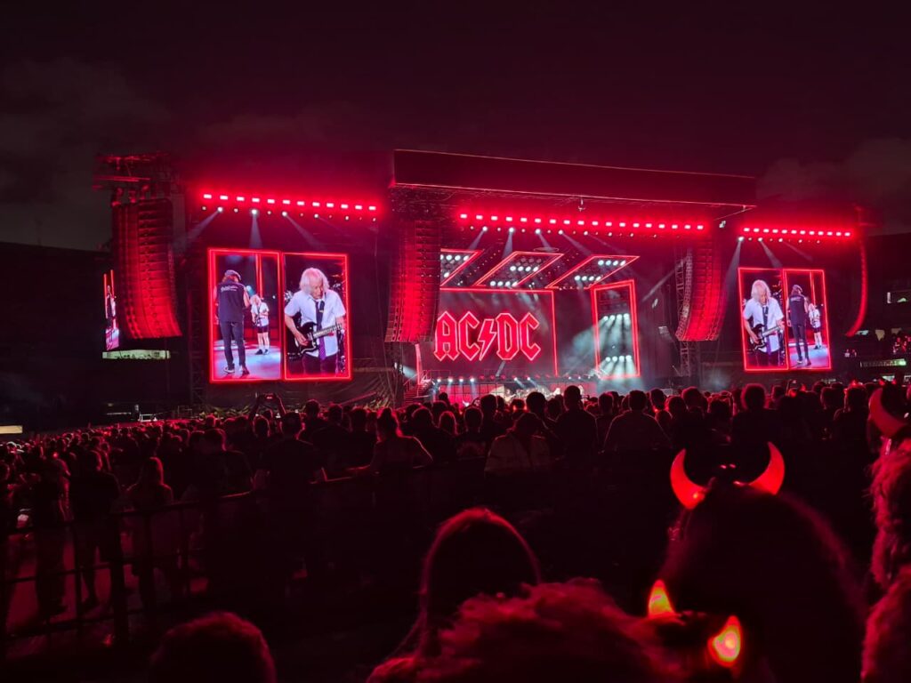 AC/DC ilumina o Morumbis em vermelho durante apresentação em São Paulo, com estádio lotado e fãs acompanhando cada clássico da banda.