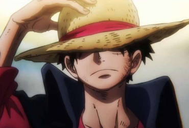 Close em um personagem de anime usando um chapéu de palha com faixa vermelha, ajustando a aba com a mão. A luz dourada ao fundo cria um clima de determinação e silêncio antes da ação.