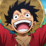 Monkey D. Luffy, personagem de One Piece, aparece sorrindo com a boca aberta e os braços erguidos, usando chapéu de palha e camisa vermelha, com céu azul e vegetação ao fundo.