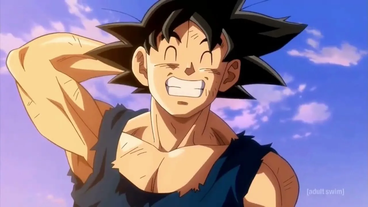 Goku, personagem de Dragon Ball, aparece sorrindo com os olhos fechados e os dentes à mostra, com a mão atrás da cabeça, usando roupa rasgada, com céu azul e nuvens ao fundo.