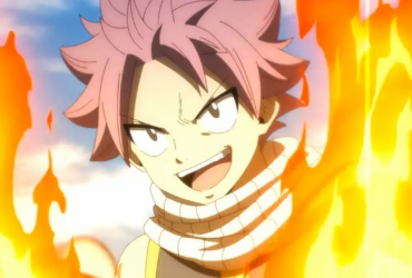 Natsu Dragneel, personagem de Fairy Tail, com expressão determinada e punho à frente, cercado por chamas alaranjadas, pronto para atacar.
