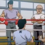 Cena do anime Hajime no Ippo mostrando um treino no ginásio de boxe: Ippo com luvas em um ringue, conversando enquanto Nakamura e outros membros do time observam ao redor.
