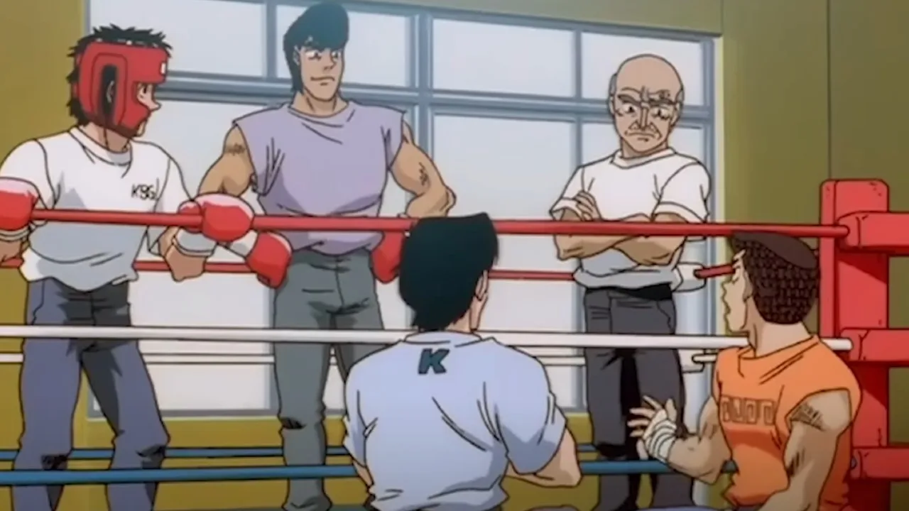 Cena do anime Hajime no Ippo mostrando um treino no ginásio de boxe: Ippo com luvas em um ringue, conversando enquanto Nakamura e outros membros do time observam ao redor.