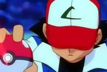 Ash Ketchum segurando uma Pokébola com a cabeça baixa após uma derrota, expressão abatida, representando o custo emocional da insistência e a dificuldade de parar