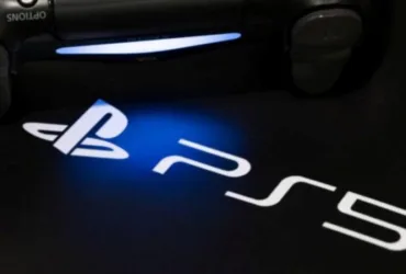 Console PlayStation sobre mesa exibindo controle e jogos digitais