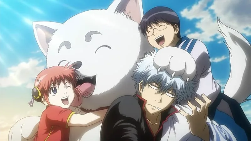 Gintoki Sakata aparece sentado com Sadaharu sobre a cabeça, enquanto Kagura sorri ao lado do grande cachorro branco e Shinpachi ri atrás deles, sob um céu azul. A cena mostra o clima de família improvisada da Yorozuya em Gintama.