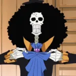 Brook, personagem esqueleto de One Piece, aparece de frente com um grande cabelo afro preto, casaco escuro com detalhes amarelos e laço azul no pescoço. Ele segura as lapelas da roupa em um ambiente de madeira, ao lado de uma cortina azul.