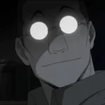 Shou Tucker, personagem de Fullmetal Alchemist, aparece em close em um laboratório escuro. Seus óculos redondos refletem uma luz branca intensa e escondem seus olhos, enquanto ele exibe um sorriso discreto. Ao fundo, prateleiras com frascos reforçam a atmosfera fria, científica e inquietante da cena.