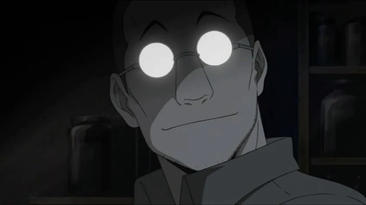 Shou Tucker, personagem de Fullmetal Alchemist, aparece em close em um laboratório escuro. Seus óculos redondos refletem uma luz branca intensa e escondem seus olhos, enquanto ele exibe um sorriso discreto. Ao fundo, prateleiras com frascos reforçam a atmosfera fria, científica e inquietante da cena.