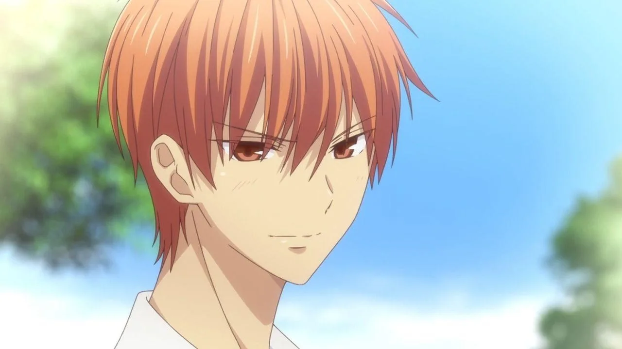Kyo Sohma, personagem de Fruits Basket, aparece em primeiro plano sob um céu azul. Ele tem cabelos alaranjados, veste uma camisa branca e olha para o lado com expressão séria, leve rubor no rosto e um sorriso discreto. A imagem transmite vulnerabilidade, hesitação e um instante de carinho contido.