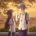 Yuki Sohma e Tohru Honda, personagens de Fruits Basket, estão lado a lado em uniforme escolar ao entardecer. Yuki, de cabelo cinza, segura um pequeno objeto diante de Tohru, que olha para ele. Árvores, folhas ao vento e uma luz dourada de pôr do sol criam uma atmosfera de cuidado, calma e conexão.