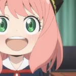 Anya Forger, personagem de Spy x Family, aparece em close sorrindo com os olhos verdes bem abertos. A garota tem cabelo rosa, presilhas pretas e douradas e usa uniforme escolar escuro com laço vermelho, diante de uma cortina verde.