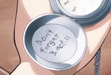 Mão segura o relógio de bolso prateado de Edward Elric aberto, com a inscrição “Don’t Forget 3.Oct.11” gravada na parte interna da tampa.